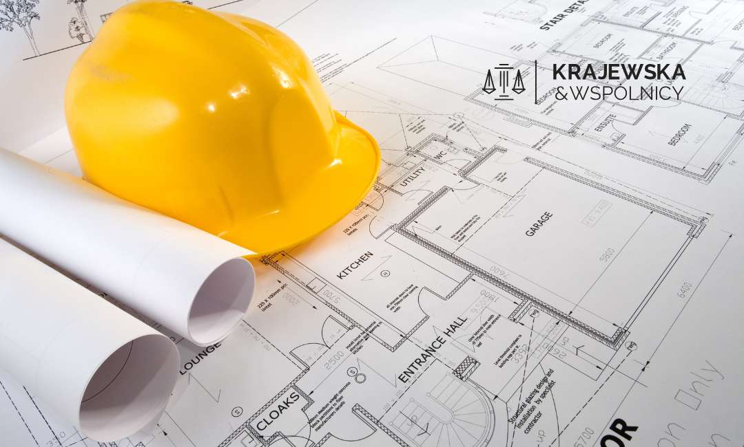Żółty kask ochronny leżący na planach budowalnych