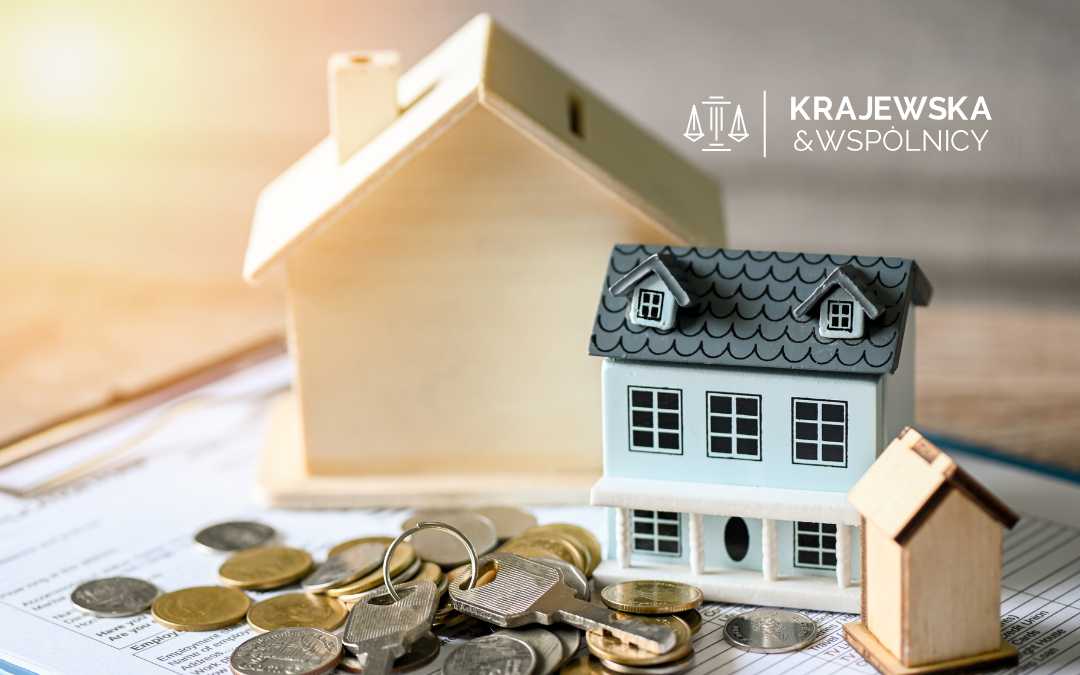 Drewniany domek skarbonka, monety oraz klucze do domu - symbol sprzedaży nieruchomości