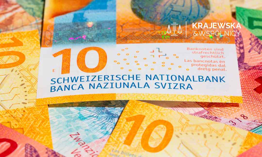 Zbliżenie na banknot szwajcarski o nominale 10 franków, który leży na innych kolorowych banknotach