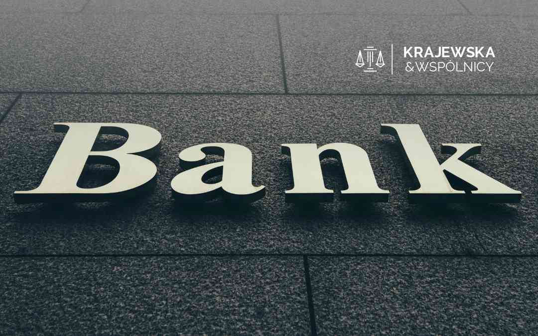 Napis Bank na kamiennej elewacji budynku z logotypem Kancelarii Krajewska i Wspólnicy.