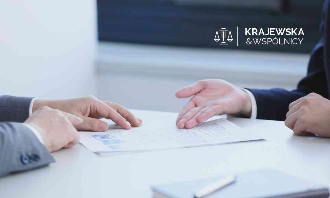 Prawnik analizuje umowę kredytu pod kątem klauzul abuzywnych podczas spotkania – logo Krajewska & Wspólnicy.