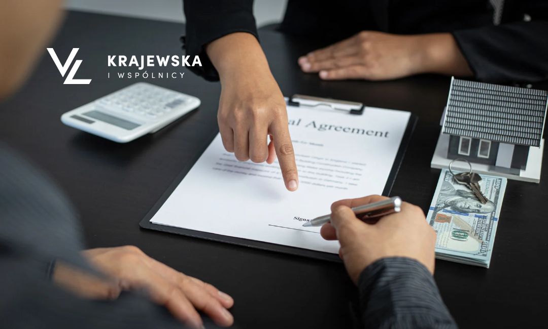 Dwie osoby siedzące przy biurku, na którym leżą dokumenty kalkulator i pieniądze. Jedna osoba wskazuje na te dokumenty, druga je podpisuje.